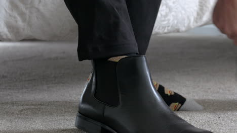 Man-Pulls-On-Black-Blundstone-Boots,-CLOSE-UP