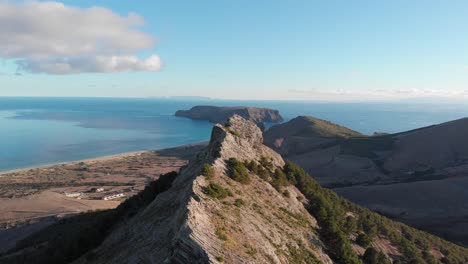 Impresionante-Vuelo-Por-Encima-Y-A-Lo-Largo-De-La-Montaña-De-La-Cresta-De-Ana-Ferreira-En-La-Isla-De-Porto-Santo-Con-Vistas-Panorámicas-Del-Vasto-Océano-Azul,-Archipiélago-De-Madeira,-Portugal,-Enfoque-Aéreo-Superior