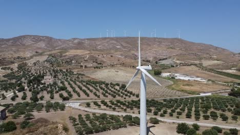 Wind-turbine-generating-sustainable-energy-for-European-farm,-wind-farm-backdrop