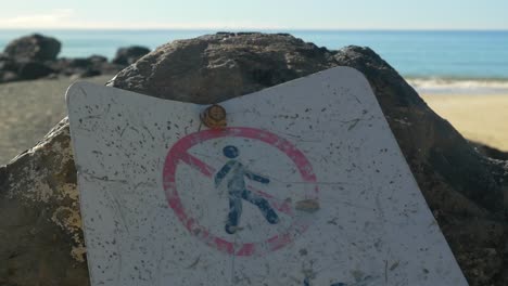 Pictogram-Of-A-Dirty-Not-For-Public-Access-Signage-Screwed-On-The-Rock---Palm-Beach,-Gold-Coast---Queensland,-Australia---close-up