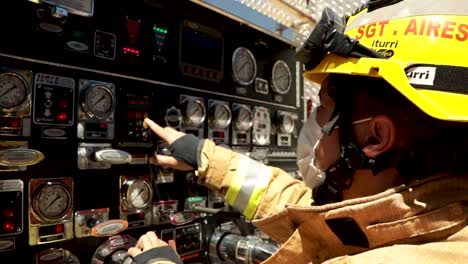 Feuerwehrmann-überprüft-Die-Ausrüstungstafel-Des-Feuerwehrautos,-Während-Er-Auf-Einen-Brand-In-Einem-Krankenhaus-Zur-Behandlung-Von-Covid-19-Reagiert