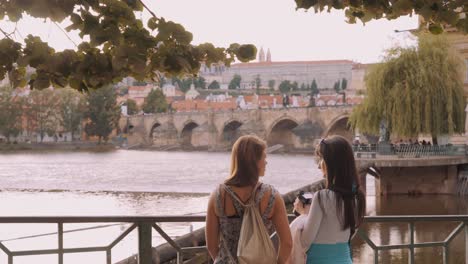 Tourists-looking-at-Charles-Bridge-over-the-Vltava-River,-Prague,-Czech-Republic