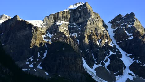 Schatten-Kriechen-Und-Wachsen-Diesen-Schneebedeckten-Berg-Hinauf,-Während-Die-Sonne-In-Diesem-Dramatischen-Zeitraffer-Untergeht-–-Banff-Nationalpark-Zeitraffer