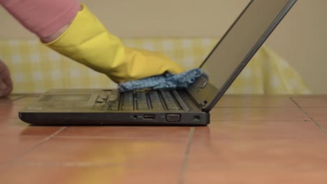 Hands-in-rubber-gloves-cleaning-laptop-with-cloth-medium-shot