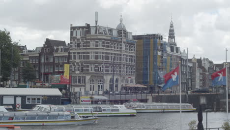 Tour-boats-passing-through-canal-in-the-city-centre-of-Amsterdam
