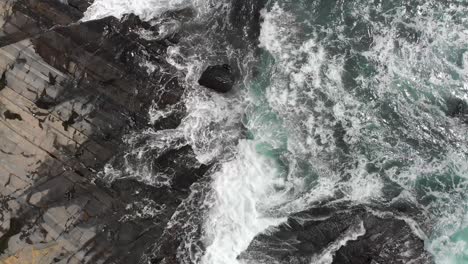 Aerial:-waves-crashing-against-rocky-coast