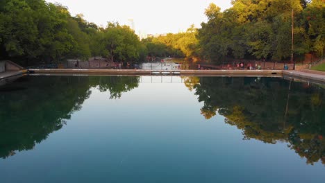Quick-pan-up-from-barton-springs-pool,-down-barton-creek,-revealing-downtown-Austin-Texas