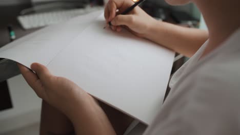 Close-up-shot-of-young-woman-learning-to-draw-on-paper-with-a-pencil