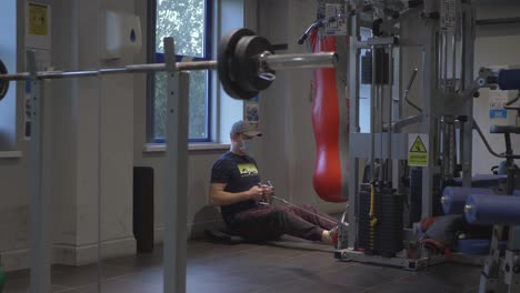 Man-With-A-Mask-Amateur-Moves-Weightlifter-Dumbbells-In-The-Gym