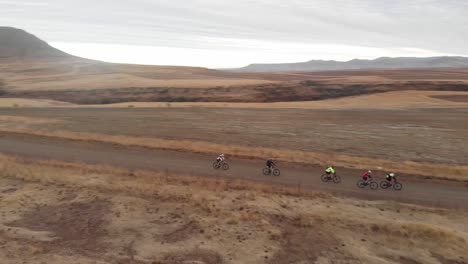 aerial-rotating-shot-of-mountain-bikers-on-a-gravel-road