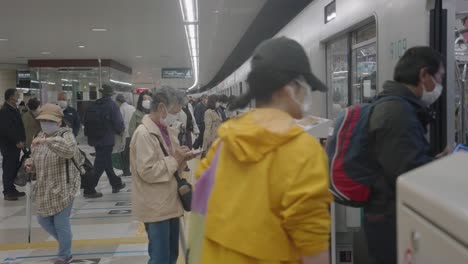 Pasajeros-Con-Mascarillas-Entrando-En-Un-Tren-En-Tokio,-Japón---Brote-De-Pandemia-De-Coronavirus