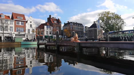 Low-angle-shot-of-Leiden-river,girl-sitting-on-bridge-during-beautiful-summer-day-in-Netherlands