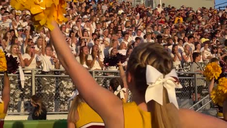 Cheerleader-Der-High-School-Begeisterten-Die-Menge-Während-Eines-Fußballspiels
