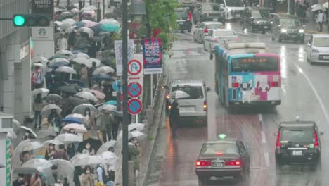Multitud-De-Personas-Con-Paraguas-Esperando-Para-Cruzar-En-El-Cruce-De-Shibuya-En-Un-Día-Lluvioso-En-Tokio,-Japón
