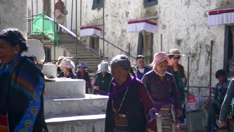 Pilgrims,-locals,-and-tourists-walking-on-the-street-of-Tashilhunpo-Monastery-in-Tibet,-China-on-a-sunny-day