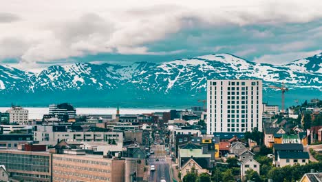 Timelapse-of-tromso,-clouds-moving-in-from-the-south-as-we-see-cars-and-people-down-the-main-street-of-tromso