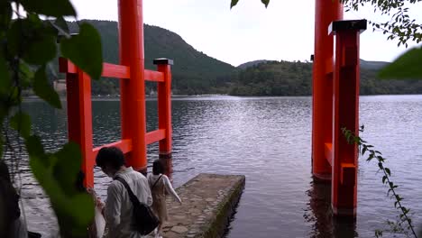 Slow-motion-push-out-between-trees-at-Hakone-Shrine-with-tourists-taking-pictures