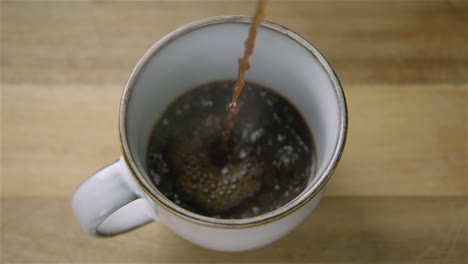 150fps-SLOW-MOTION-WIDE-black-coffee-pours-into-a-cup,-splashing