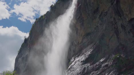 Tilt-down-shot-of-Dramatic-Giant-Waterfall-Flowing-In-swiss-village