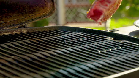 Placing-a-raw-steak-on-a-hot-grill