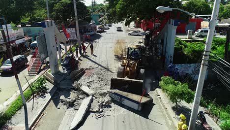 Aerial-view-of-a-bulldozer-cleaning-a-traffic-accident-scene,-in-a-city,-in-Mexico,-Central-America---reverse,-drone-shot
