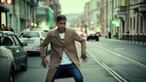 A-young-nice-looking-man-dancing-in-the-middle-of-a-road-in-a-European-city-in-the-evening