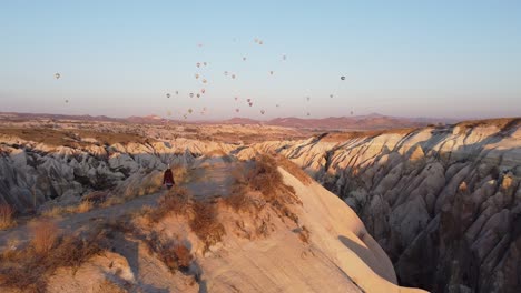 Following-a-young-girl-in-the-famous-sunrise-and-the-colorful-ballons-in-Cappadocia,-Turkey