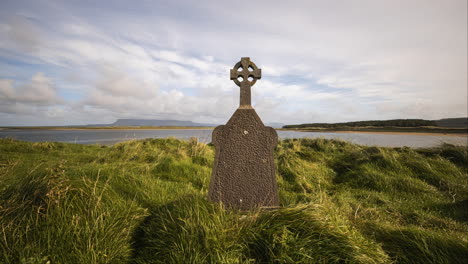 Bewegungszeitraffer-Eines-Historischen-Friedhofs-An-Der-Küste-Irlands-Mit-Hügeln-In-Der-Ferne-Und-Sich-Bewegenden-Wolken-Am-Himmel