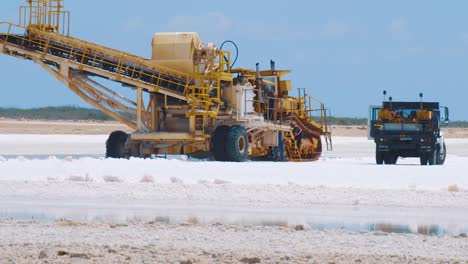 A-Conveyor-Used-In-Loading-Salt-Int-Trucks-In-Kralendijk,-Bonaire---medium-shot