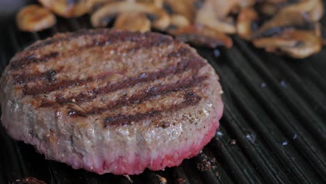 One-hamburger-patty-frying-on-medium-heat-in-a-cast-iron-grill-skillet