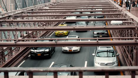 Stream-Of-Traffic-At-Famous-Brooklyn-Bridge-Spanning-East-River-In-New-York-City,-USA