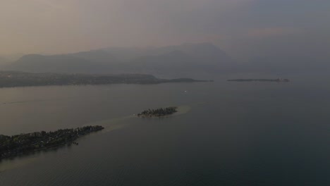 Aerial-view-of-Bay-of-Manerba-and-San-Biagio-Island-on-lake-Garda-at-sunrise