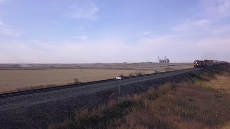 Cattle-feedlot-in-back-as-CP-Rail-freight-train-approaches-in-front