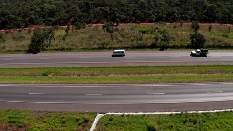 Van-or-small-bus-driving-down-the-highway---aerial-side-follow-view