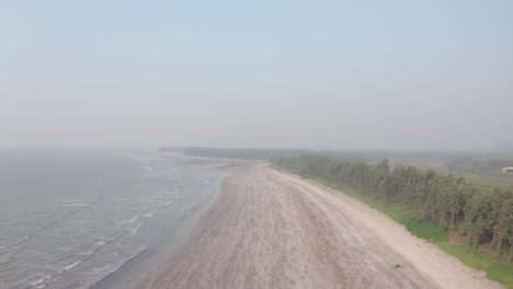 descending-drone-shot-over-empty-sandy-beach-on-a-hazy-day