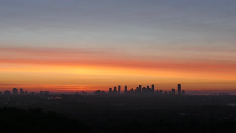 Skyline-Silhouette-Während-Eines-Wunderschönen-Goldenen-Sonnenuntergangs-Mit-Nebel