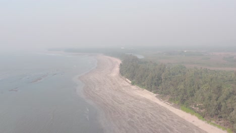 High-drone-shot-over-empty-sandy-beach-on-a-hazy-day