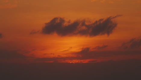Orangefarbener,-Warmer-Sonnenuntergang-Im-Zeitraffer-Mit-Großer-Sonne,-Die-Sich-Hinter-Wolken-Versteckt