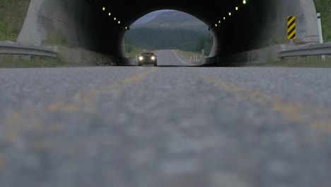 Un-Auto-Deportivo-Blanco-Visto-Conduciendo-A-Través-De-Un-Túnel-En-Una-Carretera-Vacía