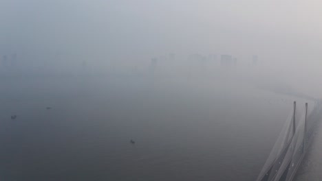 Dolly-Back-Drone-Shot-De-Mahim-Bay-Mumbai-Sealink-Bridge-En-Un-Día-Brumoso-Y-Contaminado