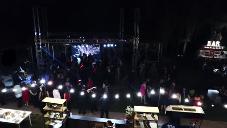 Aerial-Shot-of-Outdoor-Wedding-Band-Party-on-Large-Stage-at-Nighttime