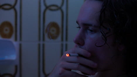 Nahaufnahme-Eines-Weißen-Mannes,-Der-In-Dunkler-Badezimmerbeleuchtung-Zigarette-Raucht