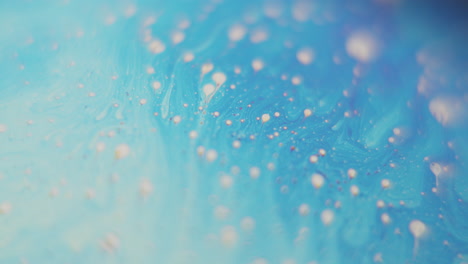 Light-blue-liquid-with-a-lot-of-small-bubbles-moving-in-slow-motion