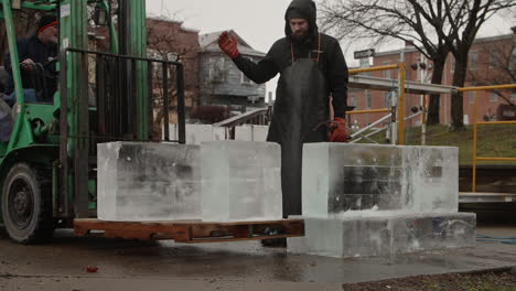 Forklift-operator-bringing-ice-blocks-to-sculptor,-Slow-Motion
