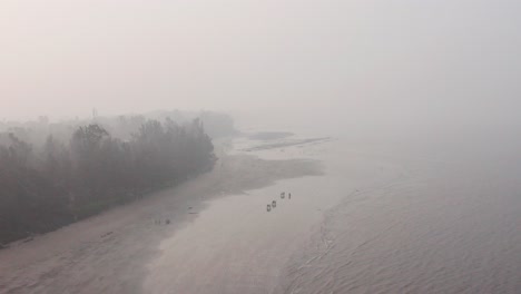 Absteigende-Drohnenaufnahme-Eines-Illegalen-Ochsenkarrenrennens-An-Einem-Strand-In-Indien