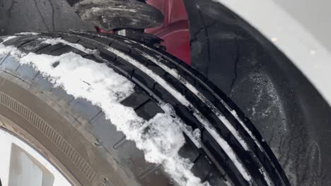 Close-shot-of-a-car-tire-with-snow