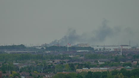 Smoke-from-huge-fire-rising-above-the-cityscape-in-Mississauga,-Canada