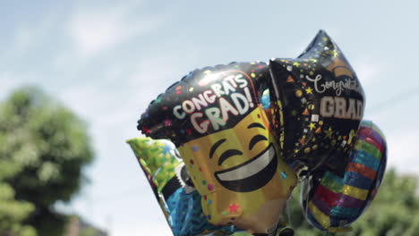 Graduation-Balloons-Float-in-the-Air-for-Celebration,-Slow-Motion,-Blue-Sky