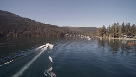 Drone-4K-Footage-of-recreational-speedboats-having-leisure-pastime-during-a-sunny-day-in-a-clam-lake-surrounded-by-mountains-canoe-buoy-homes-lakeside-shoreline-Cultus-BC-Park