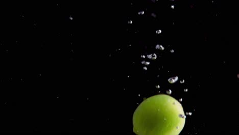 Lime-Falling-into-Water-Super-Slowmotion,-Black-Background,-lots-of-Air-Bubbles,-4k240fps